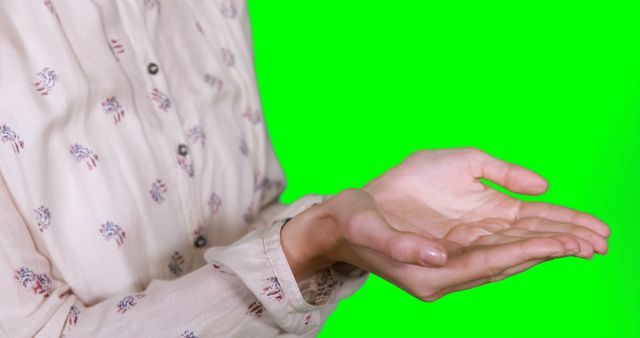 Close-up of hands holding invisible object with green background - Download Free Stock Images Pikwizard.com