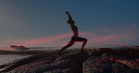 Sunset yoga silhouette stretching on rocky coast with red digital mesh overlay wellness