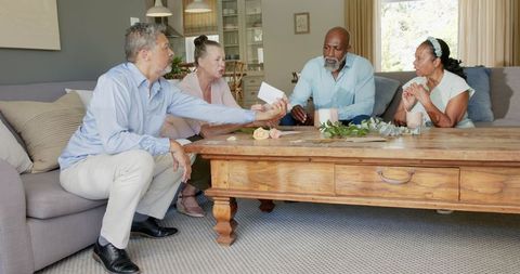 Senior group playing cards at home in casual setting