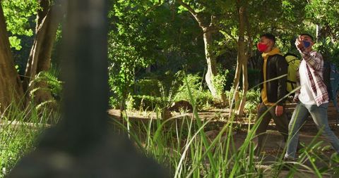 Friends Enjoying Walk in Park Amid COVID-19 with Backpacks