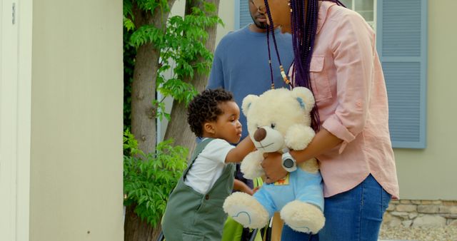 Parents Helping Child Care for Teddy Bear in Sunny Yard - Download Free Stock Images Pikwizard.com