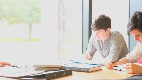 Students Studying at a Table in Bright Room