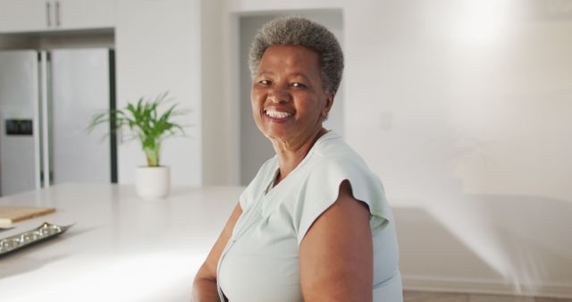 Smiling Elderly Woman Relaxing at Home in Bright Kitchen - Download Free Stock Images Pikwizard.com