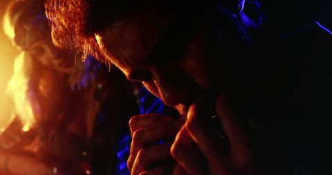 Dramatic Harmonica Performance Under Vibrant Stage Lights