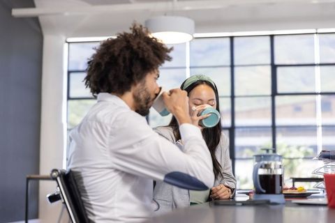 Coworkers enjoying coffee break in modern office relaxation area
