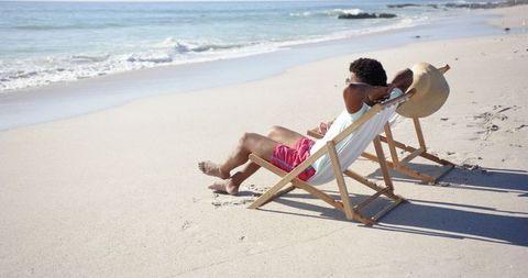 Man Relaxing on Beach Chair Beside Ocean