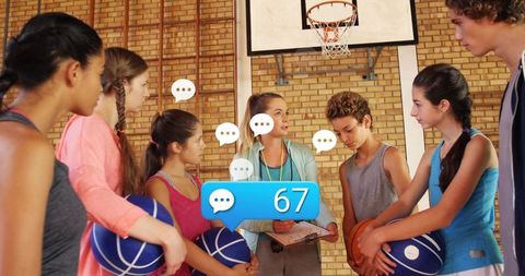 Coach guiding youth basketball team during practice, leadership huddle, teamwork training