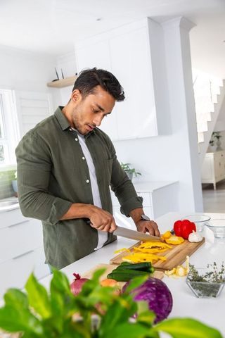Man Preparing Fresh Ingredients in Sleek Minimalist Kitchen