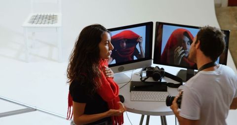 Photographer Reviewing Images with Female Model at Professional Studio