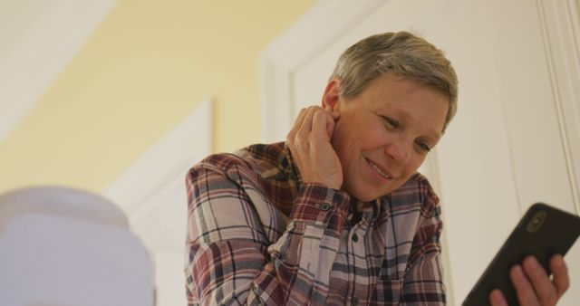 Senior Woman Smiling While Using Smartphone in Casual Home Setting - Download Free Stock Images Pikwizard.com