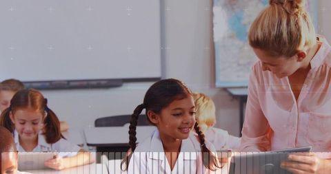 Smiling Teacher Guiding Braided Student Using Tablet in Bright Elementary Classroom