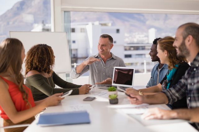 Executive leading a diverse team discussion in a modern office conference room. Ideal for business, teamwork, leadership, and corporate strategy concepts. Can be used for articles, presentations, and marketing materials highlighting professional collaboration and planning.