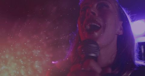 Dynamic Performer Singing Captivating Audience with Vibrant Lighting Effects