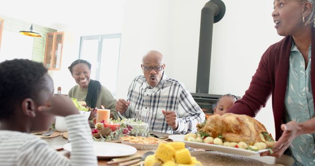Happy african american multi generation family serving food at thanksgiving dinner, slow motion. Thanksgiving, celebration, meal, home, family, togetherness,
