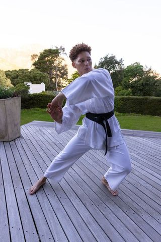 Karate Black Belt Woman Practicing Outdoors on Scenic Deck