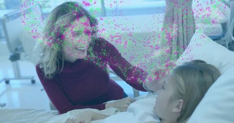 Smiling mother touching daughter's cheek sitting bedside hospital bed offering comfort