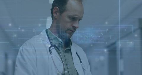 Mature Doctor Analyzing Digital Technology in Hospital Corridor