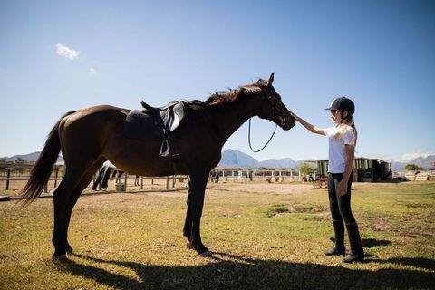 Young Equestrian Girl Bonding with Horse in Tranquil Stable Setting