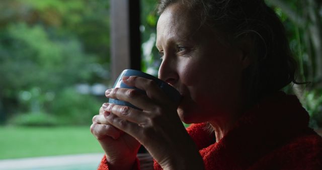 Mature Woman Sipping Hot Beverage in Lush Outdoor Setting - Download Free Stock Images Pikwizard.com