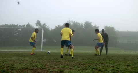 Soccer Team Practicing on a Foggy Field