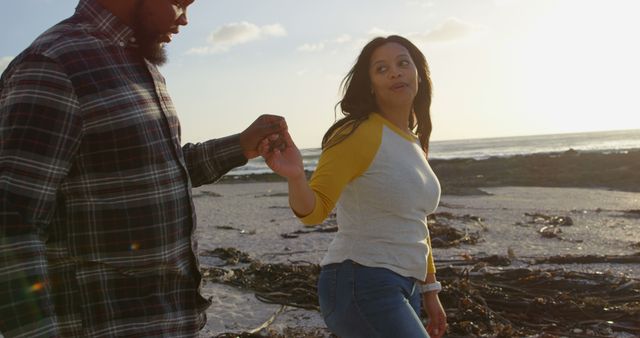 Young Couple Holding Hands on Beach at Sunset - Download Free Stock Images Pikwizard.com