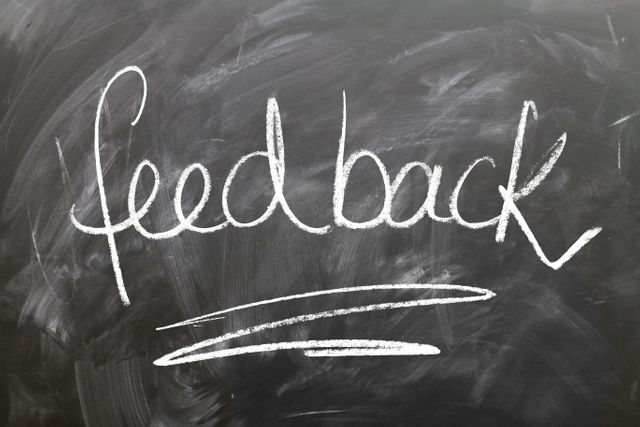 Handwritten feedback word in chalk designed on a blackboard background. Useful for educational concepts, classroom settings, consultation encouragement, school publications, teachers' materials, any design conveying feedback or reviews.