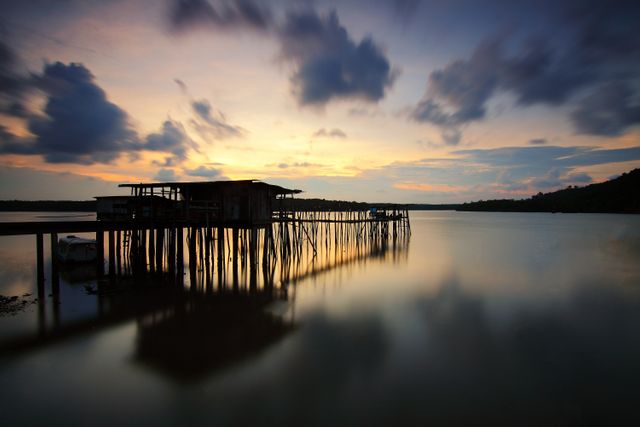 Serene Sunset over Wooden Pier on Tranquil Waters - Download Free Stock Photos Pikwizard.com