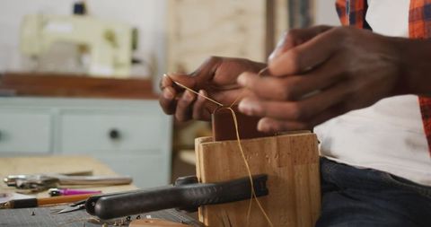 Craftsman's Hands Creating Leather Wallet in Workshop