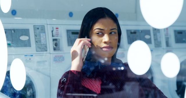 Woman on Phone in Laundromat with Washing Machines in Background - Download Free Stock Images Pikwizard.com