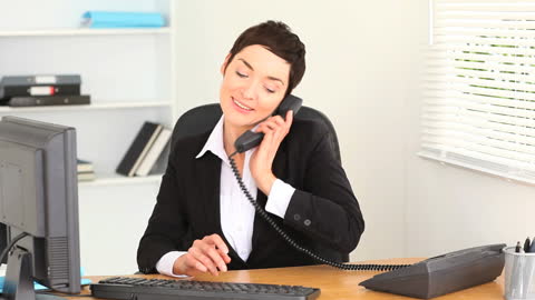 Businesswoman Balancing Phone Call and Computer Work