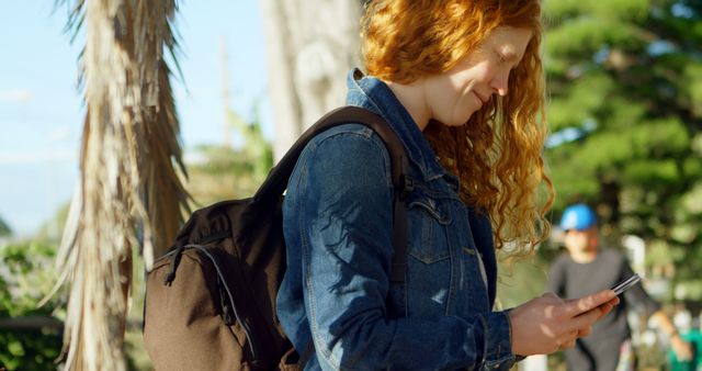 Smiling Red-haired Woman Texting Outdoors on Bright Day - Download Free Stock Images Pikwizard.com