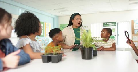 Elementary teacher leading hands-on plant science lesson with students exploring seedlings