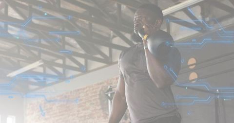 Athlete lifting kettlebell with augmented reality overlay in industrial gym space