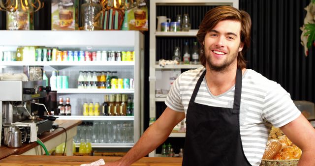 Smiling barista standing behind coffee shop counter - Download Free Stock Images Pikwizard.com