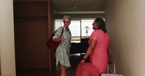 Senior lesbian couple checking into hotel room for vacation