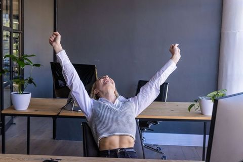 Successful Woman Celebrating Achievement at Modern Workspace