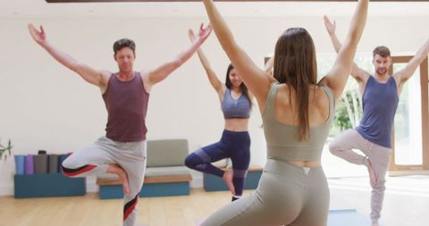 Yoga Instructor Leading Diverse Group in Studio Class