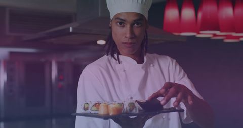 chef showing expertly prepared sushi platter in restaurant kitchen. useful for illustrating culinary expertise, professional cooking environments, and food presentation for advertisements, culinary blogs, and restaurant promotions.