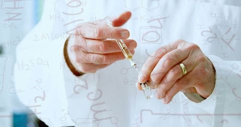 Scientist Handling Test Samples Amidst Chemistry Formulas in Lab