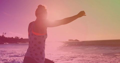Woman Stretching by the Shoreline at Sunset