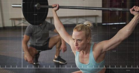 Focused weightlifter practicing barbell squats in gym