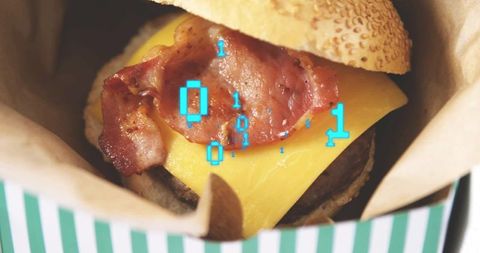Bacon cheeseburger with melted cheese and binary code overlay in striped takeout box