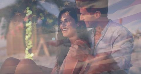 Romantic Couple Relaxing on Beach Under Starry Flag Lights