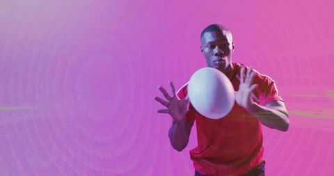 Dynamic Athlete Catches Sports Ball in Vibrant Gradient Light
