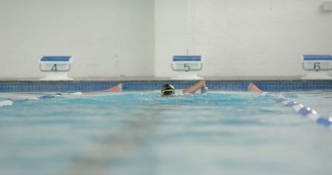 Professional swimmer practicing freestyle stroke in pool