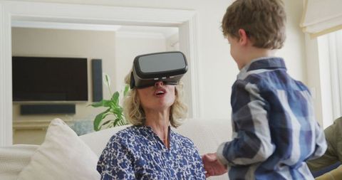 Grandmother Enjoying Virtual Reality with Grandson at Home