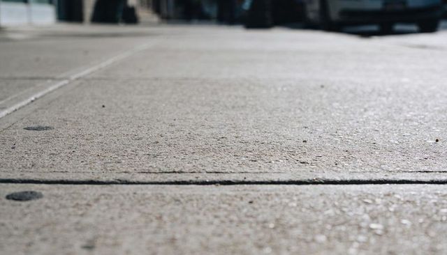 Urban sidewalk concrete texture closeup showing expansion joint, aggregate, slab detail