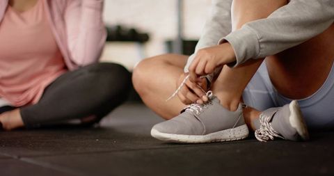 Tying sneaker laces before high-intensity workout with fitness partner
