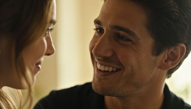 Young couple sharing tender gaze and smiling while making eye contact in cozy closeup