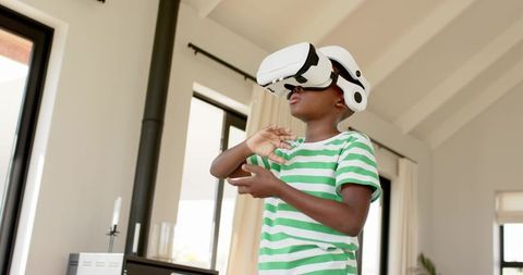 Young Boy Exploring Virtual Reality at Home Wearing White VR Headset in Sunlit Living Room
